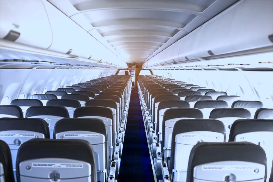 Empty airplane cabin with rows of seats.