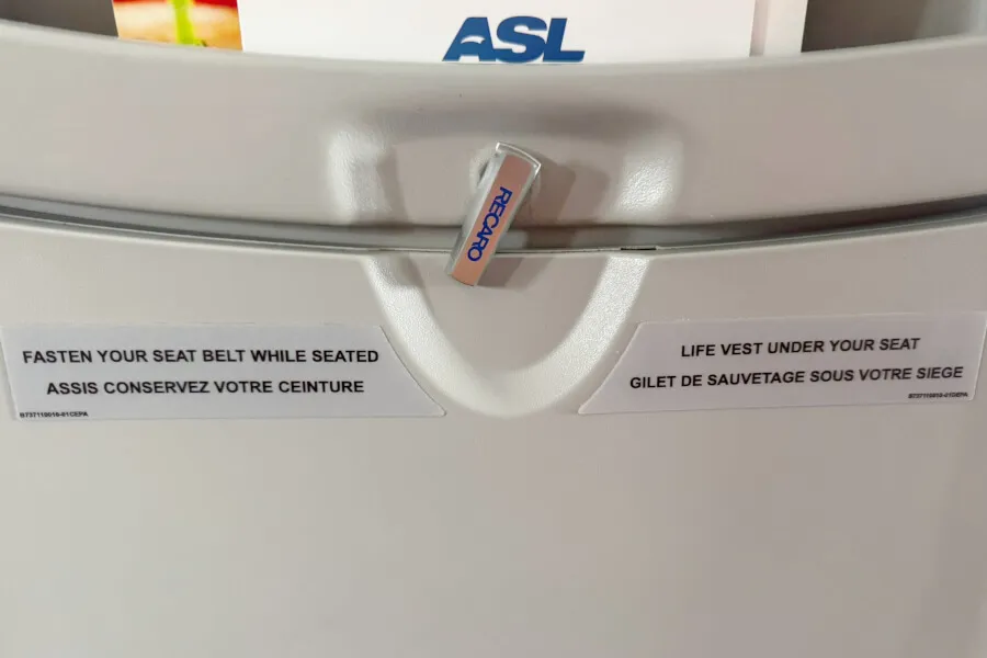 Airplane seat tray with safety instructions.