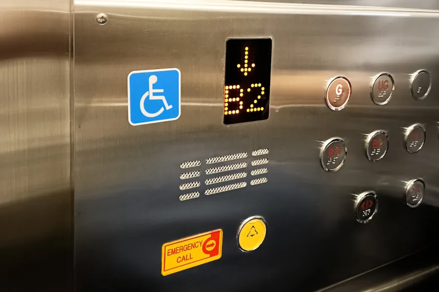 Elevator panel with accessibility and emergency buttons.