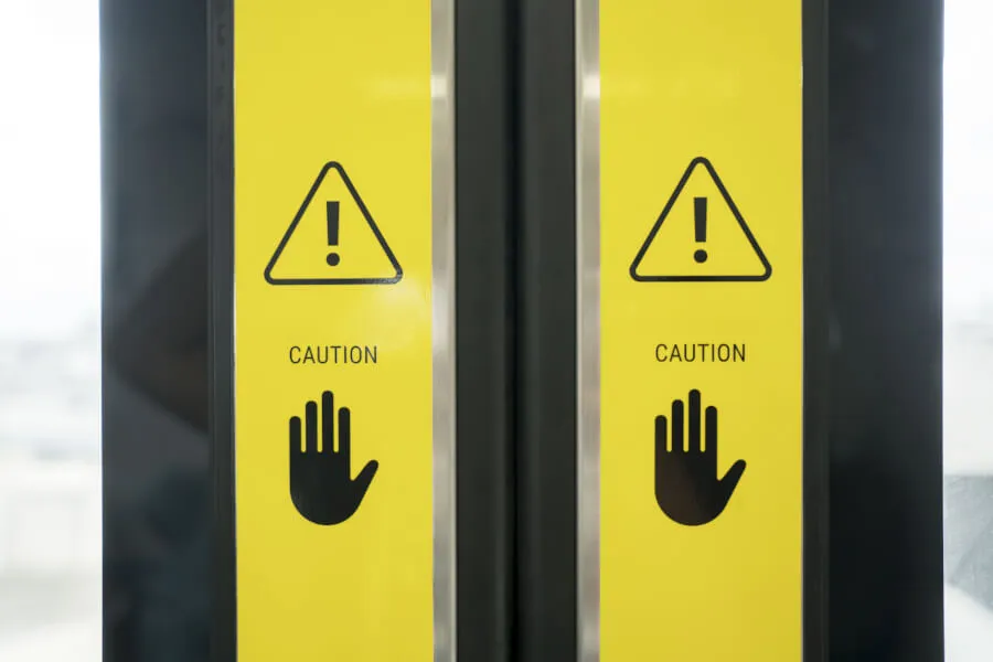 Elevator doors with caution warning signs