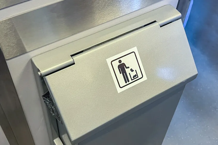 Metal trash can with disposal symbol